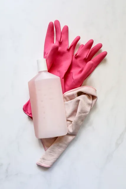Cleaning bottle, cloth and pink rubber gloves