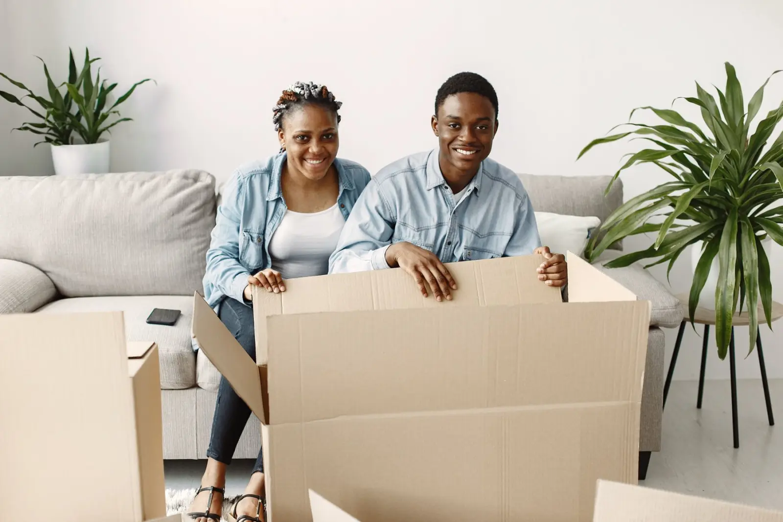 Couple relaxing behind a moving box in their new home