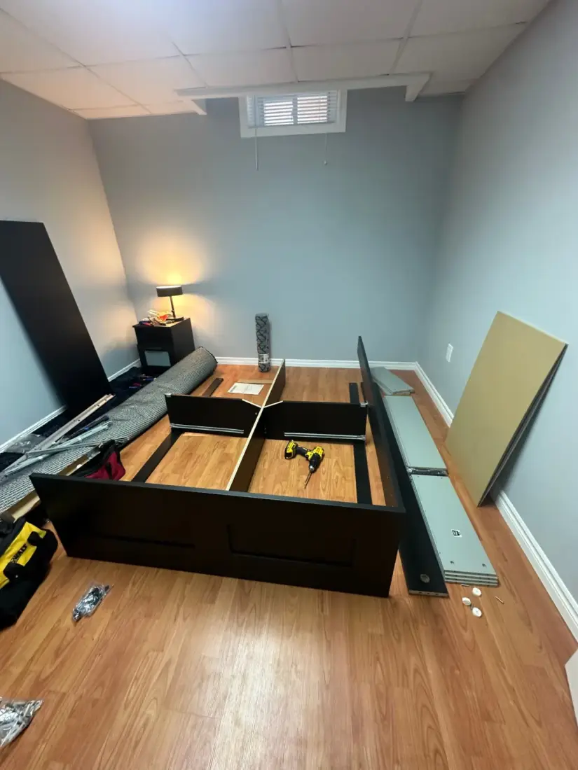 Bed frame being assembled in a room
