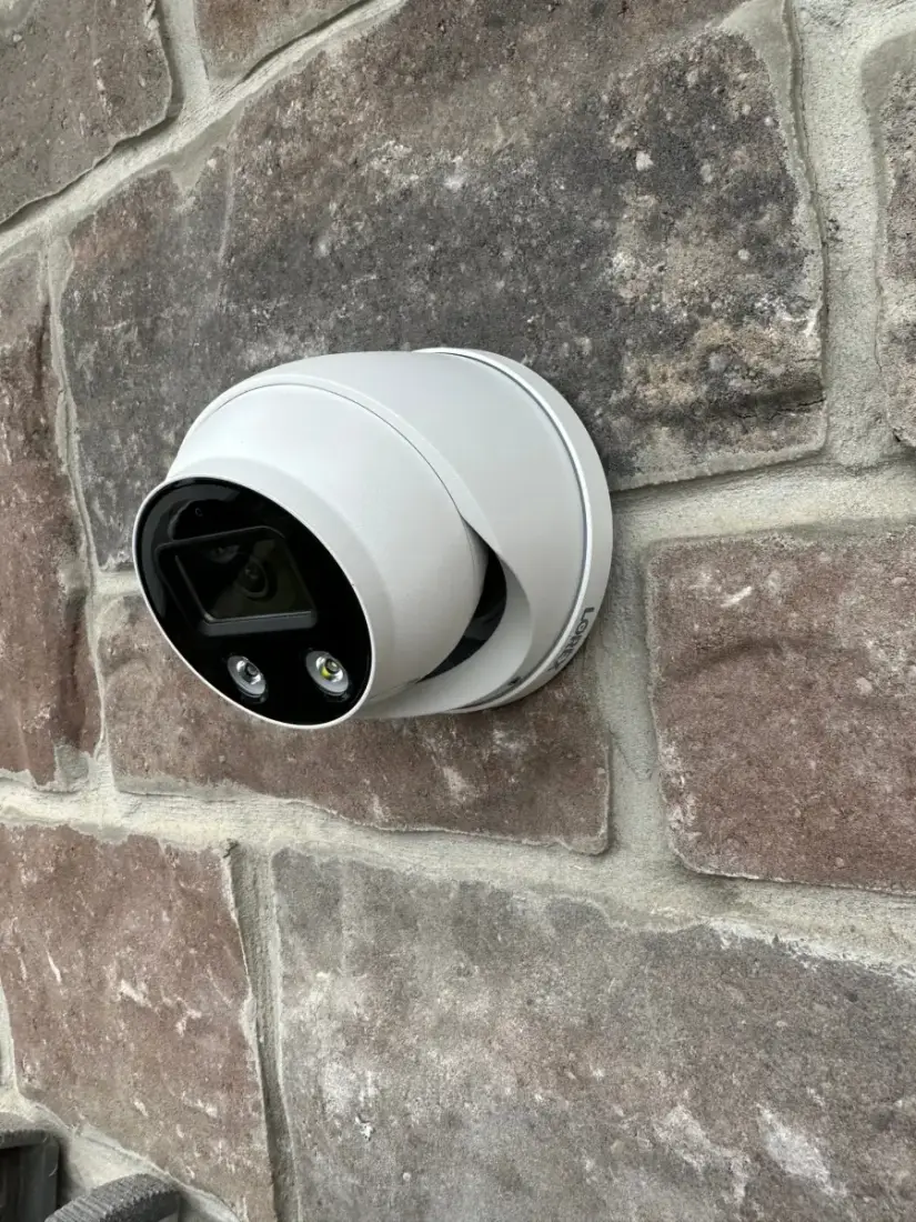 Security camera installed on an exterior stone wall